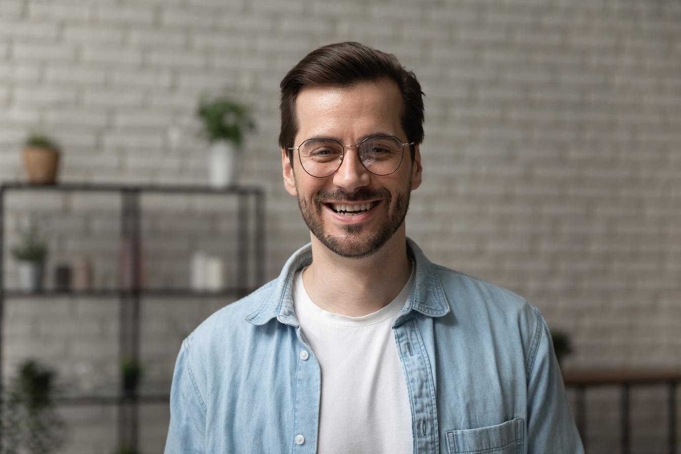 Happy young man posing for headshot portrait profile picture indoors